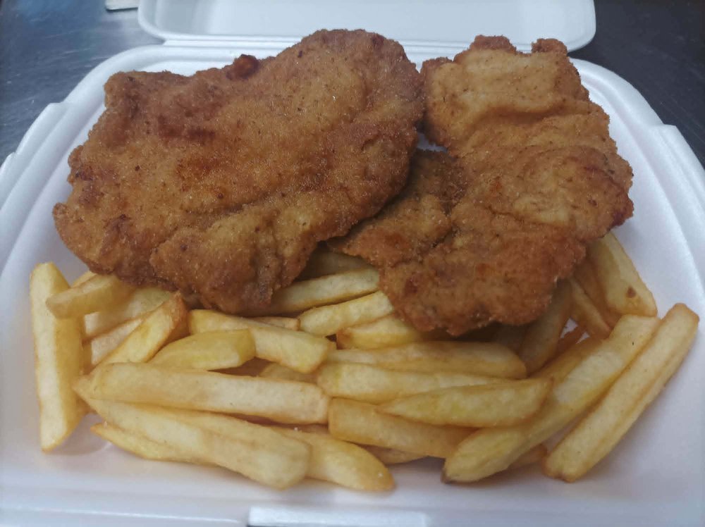 Gebackenes Schweineschnitzel mit Pommes oder Salat
